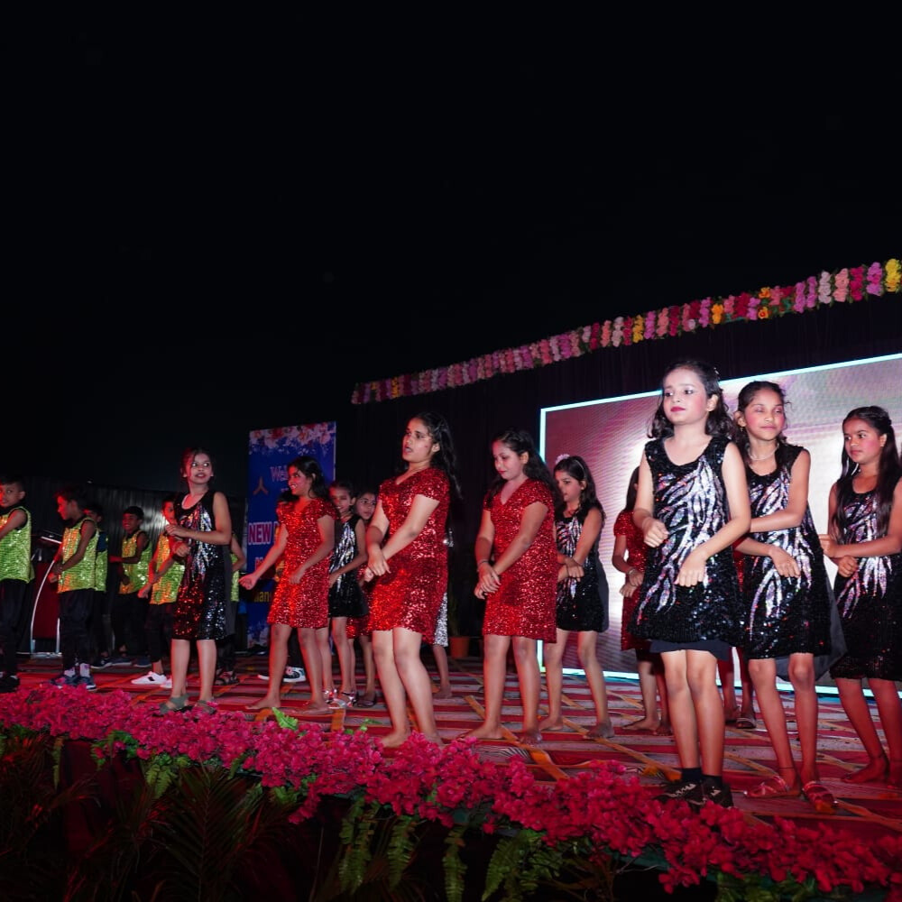 Students performing musical pieces on stage with a live audience at the school music concert.