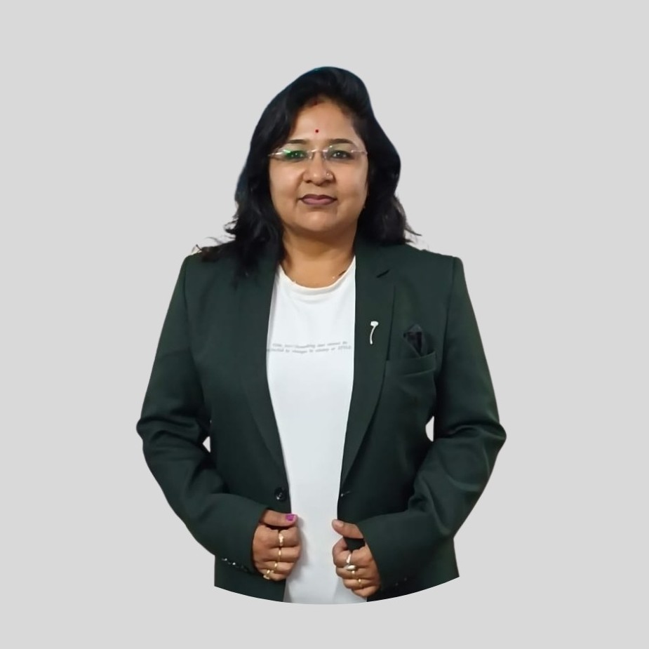 Portrait of the principal wearing a traditional green and orange sari seated at an office desk